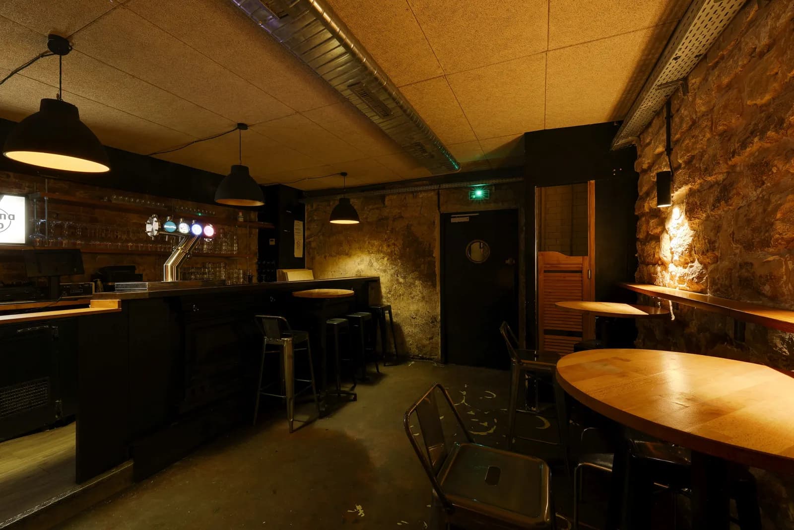 La cave, ses tables de bois et sa scène